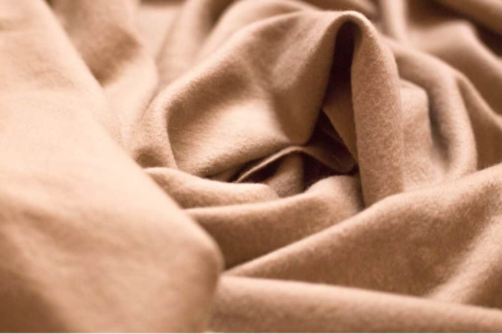 Soft beige blanket with cozy, inviting texture perfect for creating a relaxing and holistic home environment.