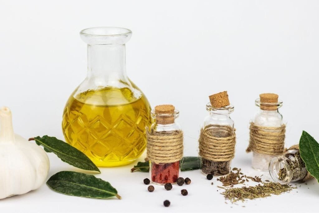 Bright herbal essential oils, spices, and fresh garlic for holistic home wellness and natural remedies in a clean, minimalist setting.