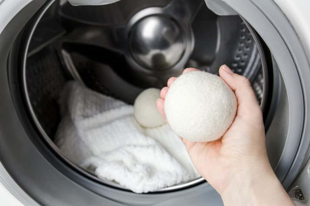 Laundry detergent pod being added to washing machine for eco-friendly cleaning and sustainable home practices.