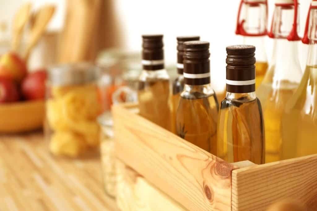Aromatherapy essential oils in glass bottles on a wooden shelf for holistic home wellness.