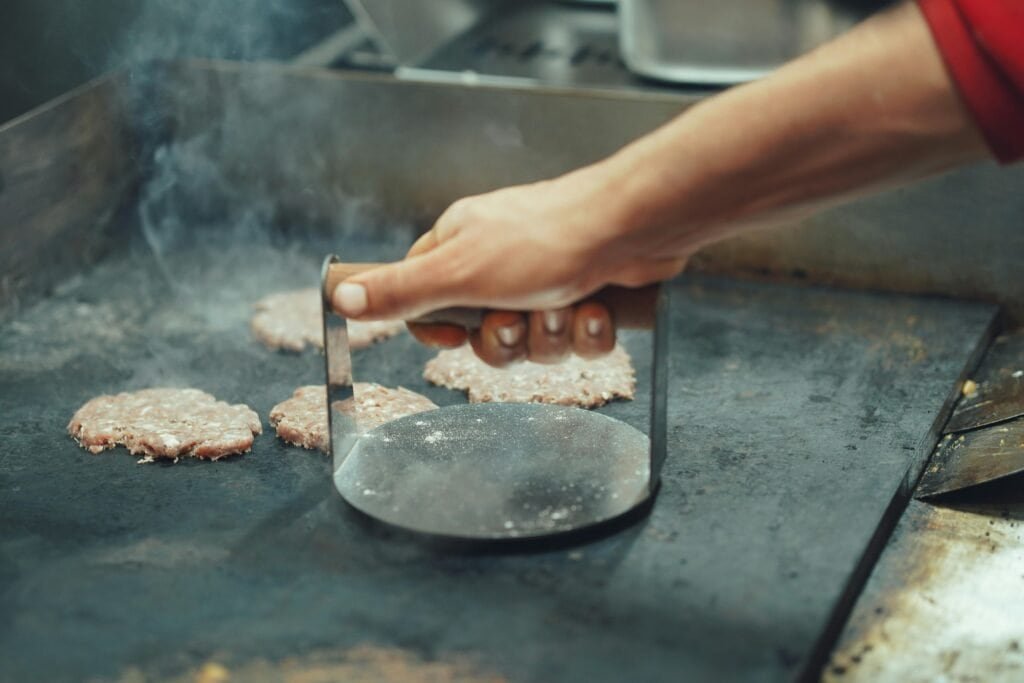 An eco-friendly cast iron burger press used for making healthy, homemade burgers with natural ingredients in a sustainable ki.